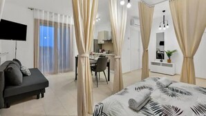 Een moderne hotelkamer met een bed, een bank, een bureau en een eethoek.