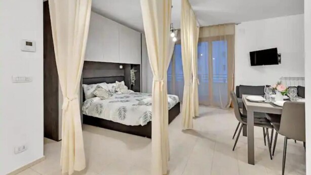 Een slaapkamer met een bed, een bureau en een stoel.