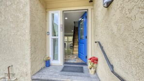 A narrow entrance with a blue door leading to a staircase. - 28 Sol Vista Complex - Spacious, Deck, BBQ, Common Pool + GOLF CART (Avalon)
