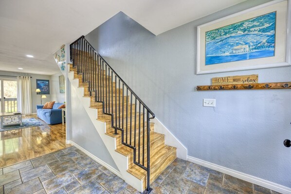 A staircase with wooden steps and black railings, leading to a landing with a framed painting and a 'HOME relax' sign. - 28 Sol Vista Complex - Spacious, Deck, BBQ, Common Pool + GOLF CART (Avalon)