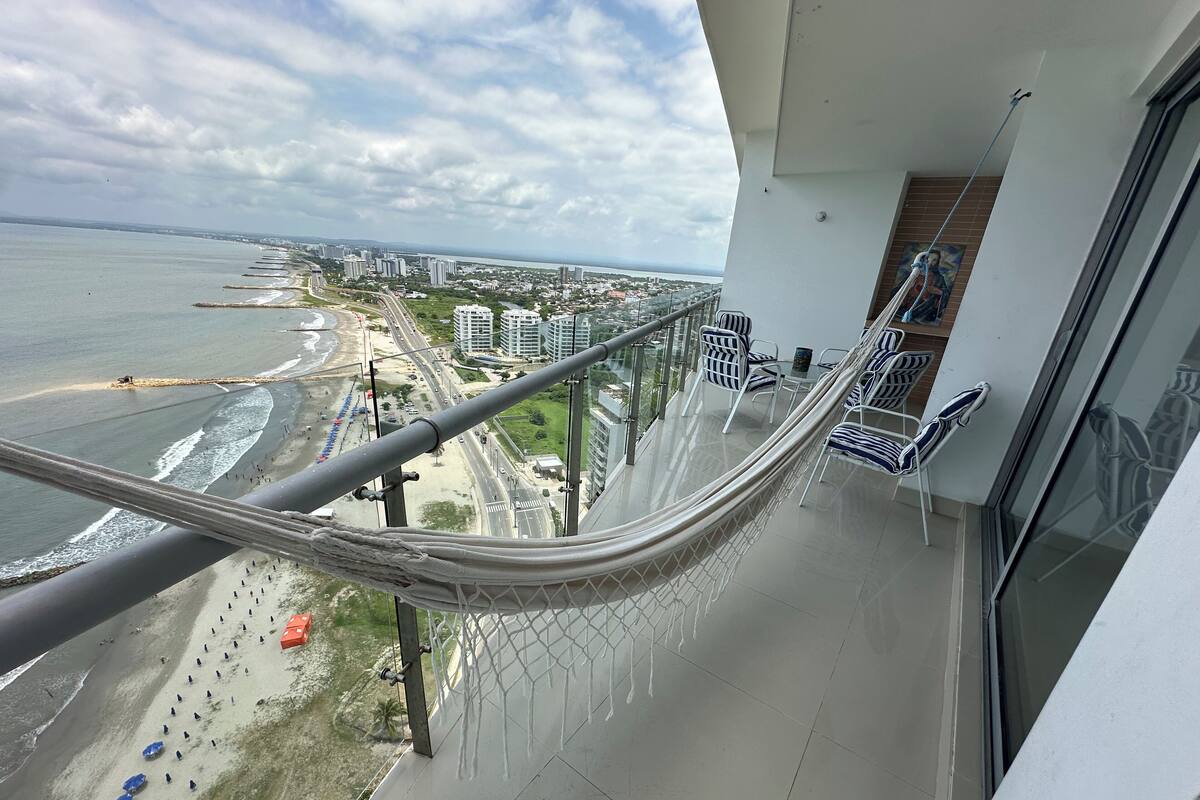 Een balkon met uitzicht op het strand, de stad en een touwbalkon.
