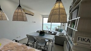 A modern kitchen with a dining area, a sofa, and a view of the sea. - Edificio Alta Mar de Marbella (Cartagena)