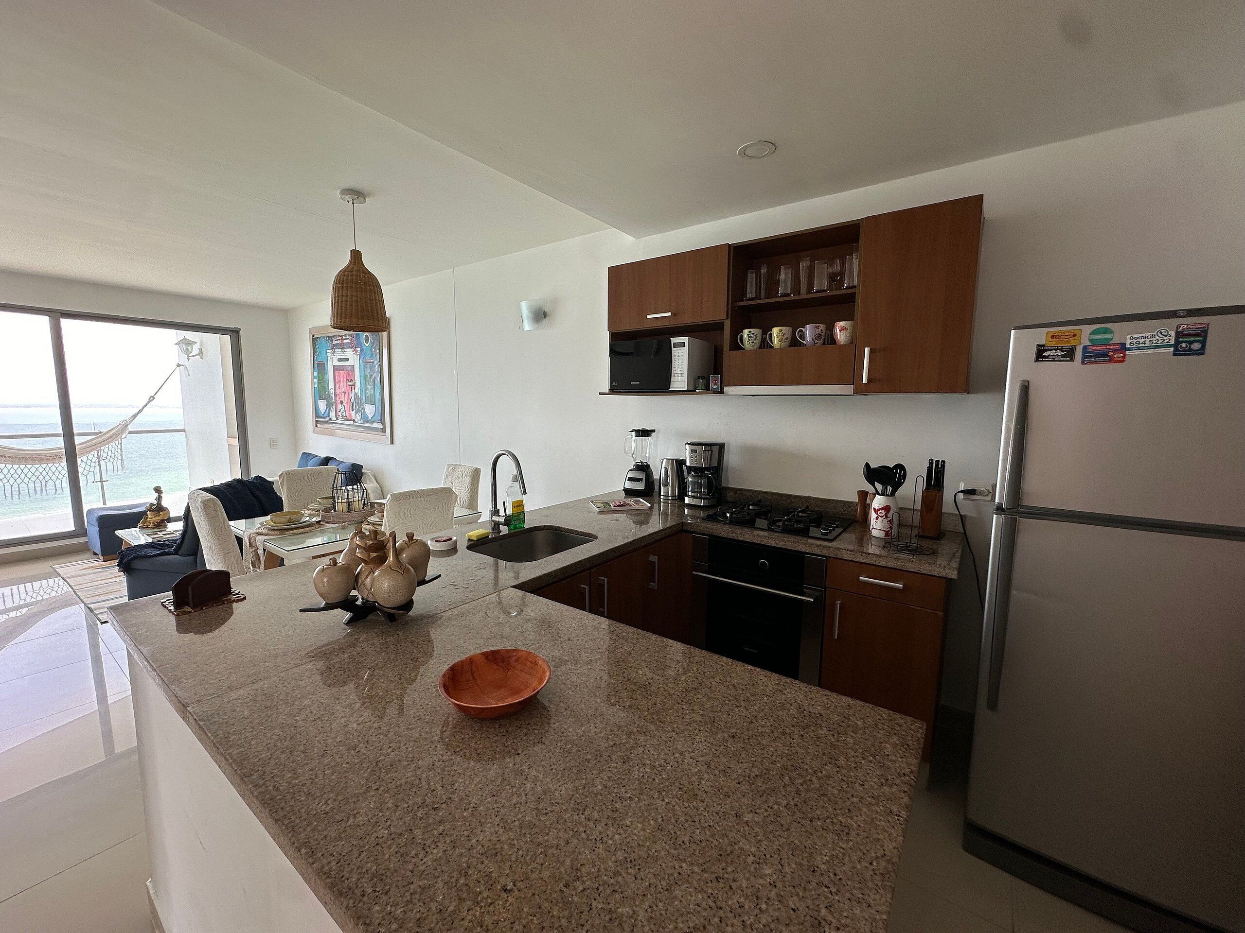 A modern kitchen with granite countertops, stainless steel appliances, and wooden cabinets.