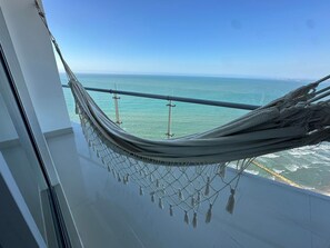 Eine Hängematte auf einem Balkon mit Blick auf den Ozean.