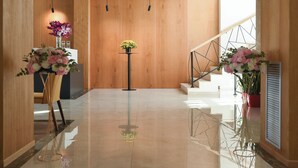 A modern lobby with wooden walls, a polished floor, and a staircase. - Hotel Albulena (Mamurras)