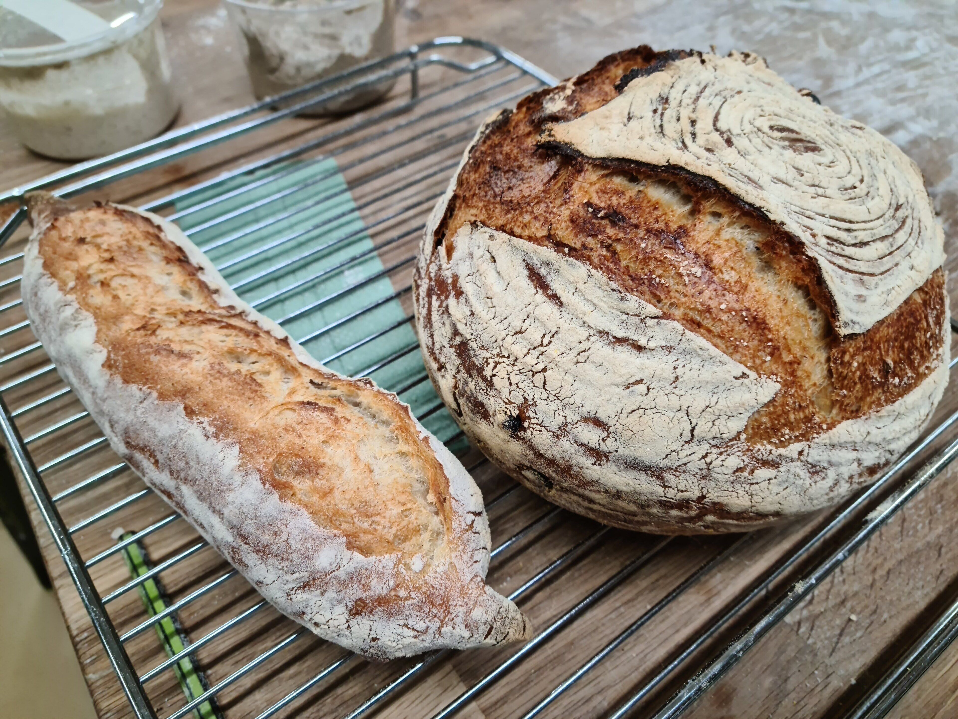 Two loaves of bread on a wire cooling rack.