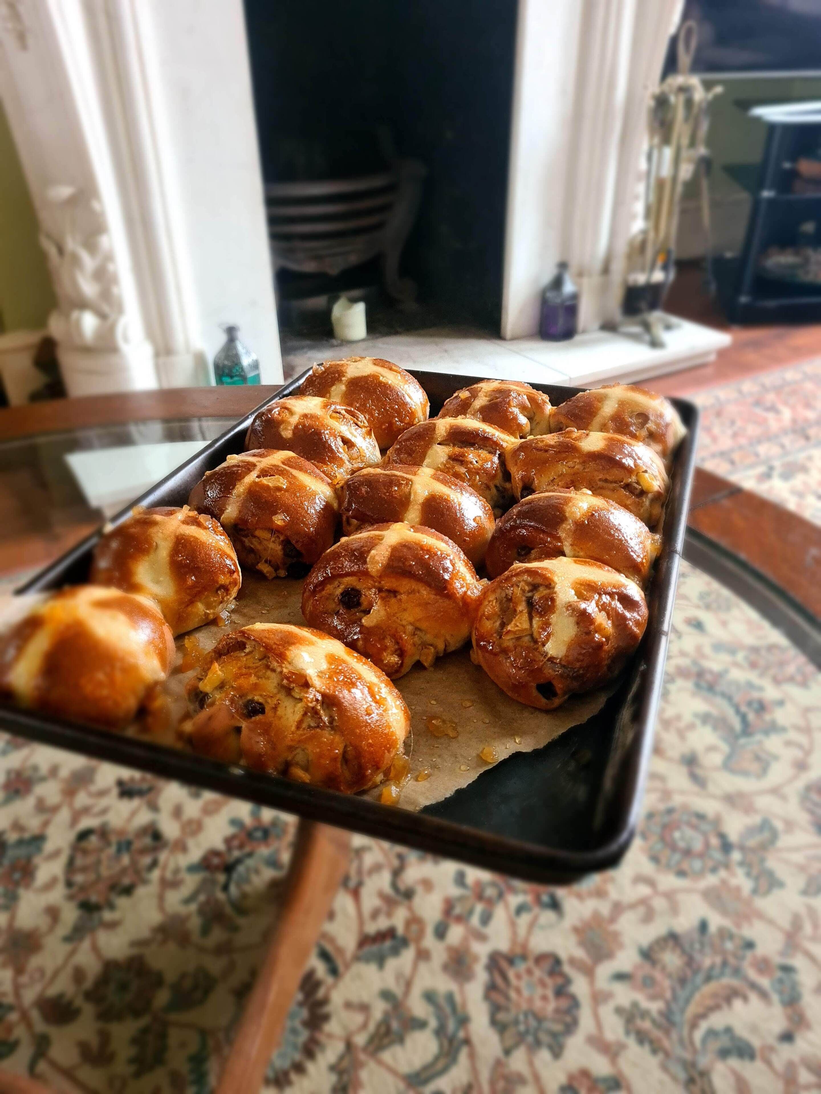 A tray of freshly baked bread rolls on a table.