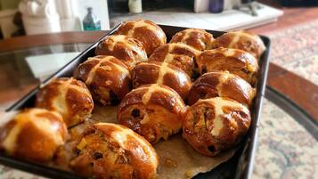 A tray of freshly baked bread rolls on a table.