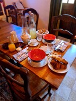 Mesa de café da manhã posta com pratos, copos e jarra de suco.