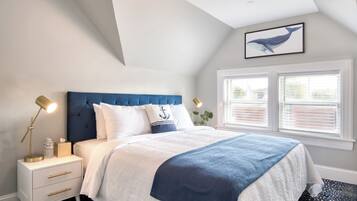 A bedroom with a bed, nightstand, lamp, and window.