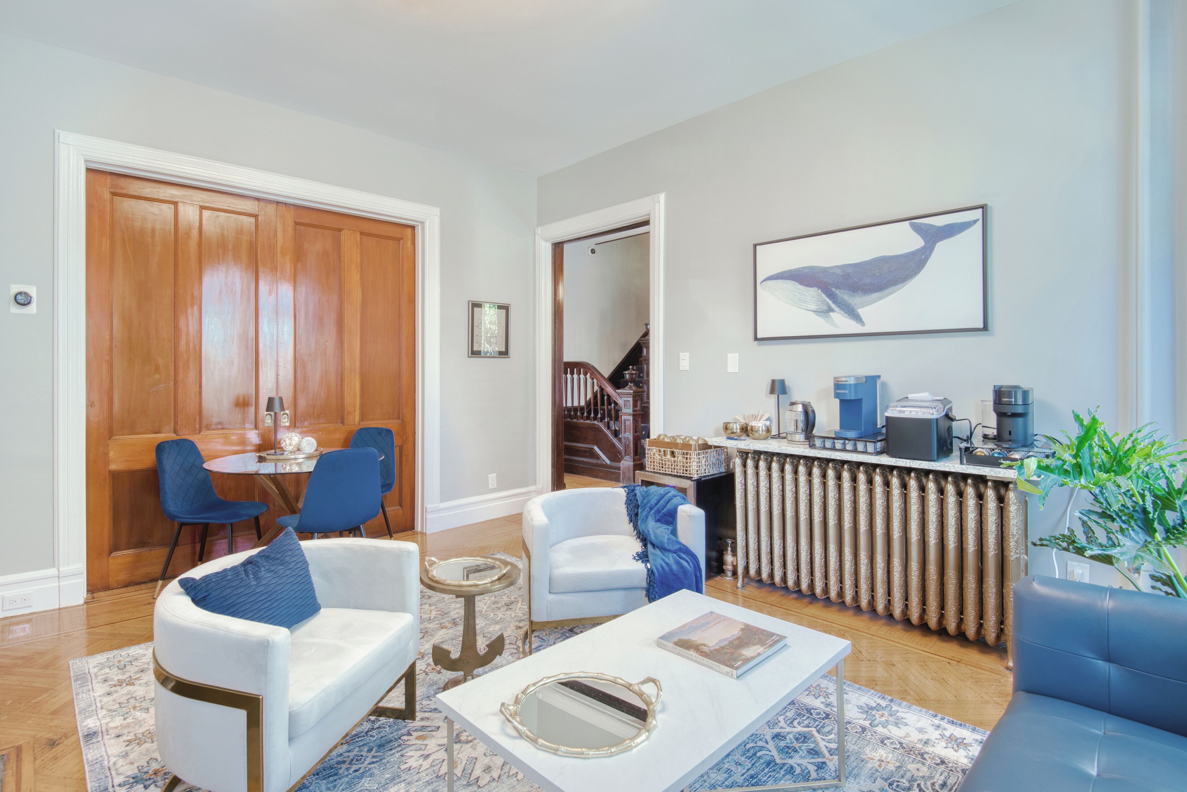 Una sala de estar moderna con comedor, cocina y una escalera que sube a otro nivel.