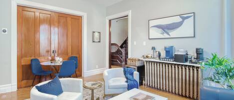 Una sala de estar moderna con comedor, cocina y una escalera que sube a otro nivel.