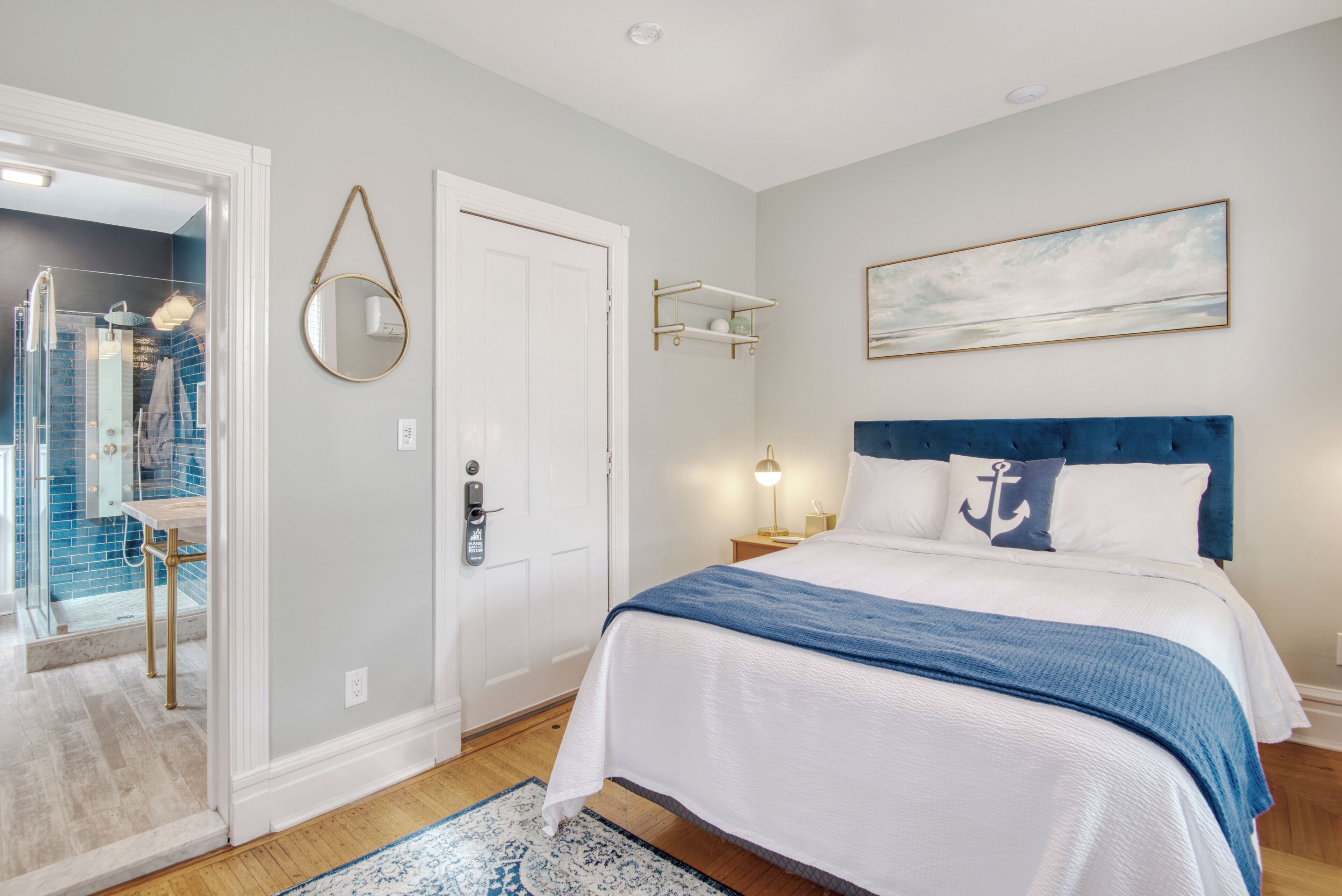 Une chambre à coucher avec un lit, une porte, une étagère fixée au mur et un tableau.
