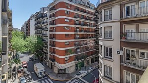 A multi-story residential building with balconies, a street view, and parked vehicles. - Comfy Studio in Recoleta with Pool & Gym (Buenos Aires)