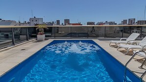 A rooftop pool with clear blue water, surrounded by lounge chairs and a glass balustrade. - Comfy Studio in Recoleta with Pool & Gym (Buenos Aires)