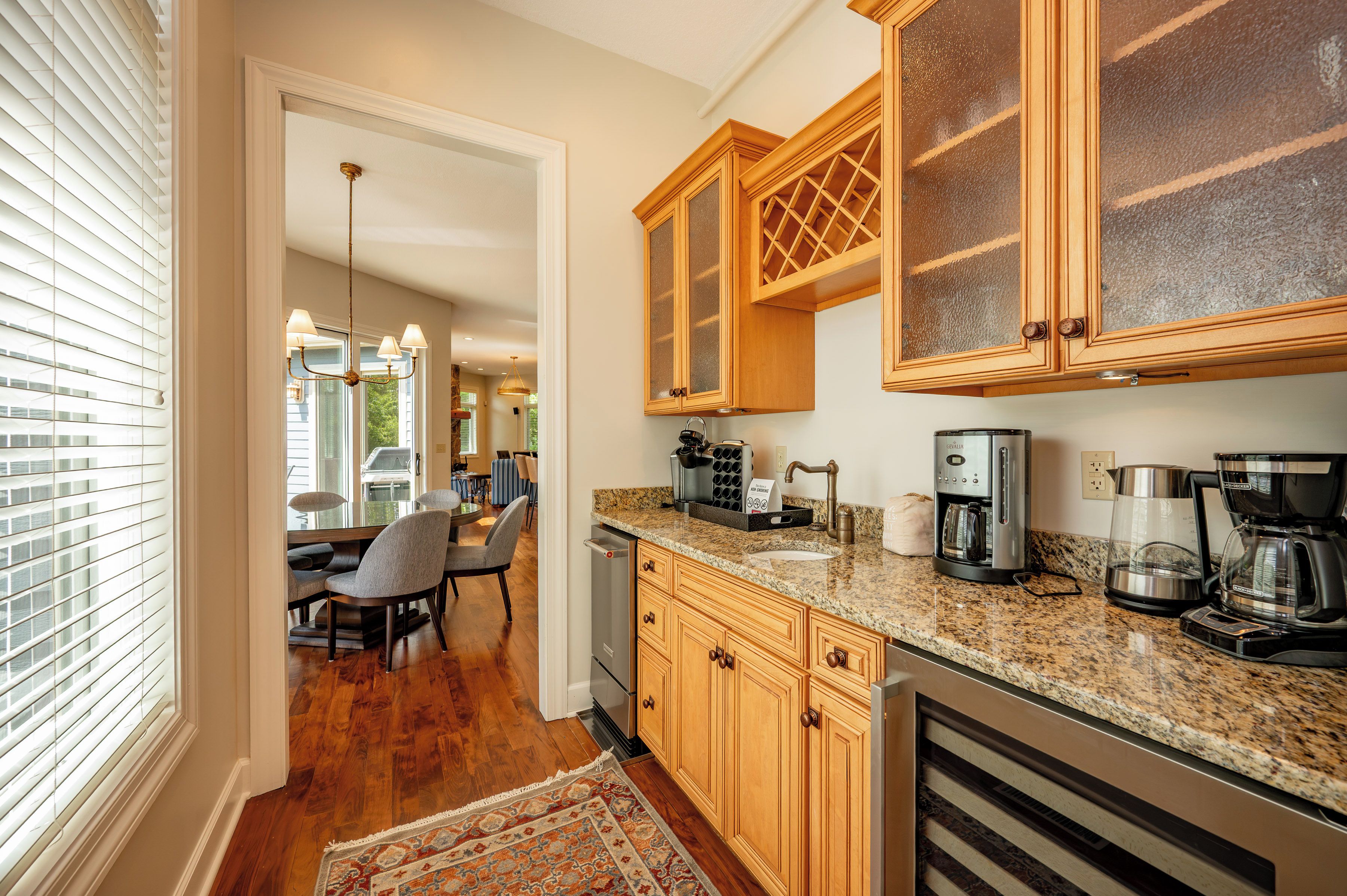 A kitchen with wooden cabinets, a granite countertop, and modern appliances including a coffee maker and toaster.
