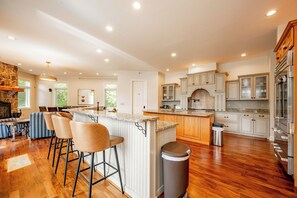 A spacious kitchen with a central island, wooden cabinets, and a stainless steel refrigerator.
