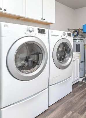 A laundry area with two front-loading washing machines and a dryer.