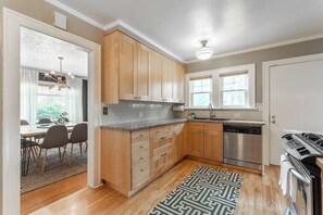 Una cocina moderna con armarios de madera, lavavajillas y estufa.