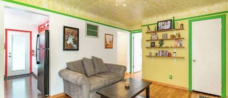Una sala de estar con sofá, mesa de centro y ventilador de techo.