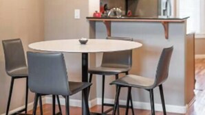 Une cuisine moderne dotée d’un îlot central, de meubles en bois et de luminaires suspendus.