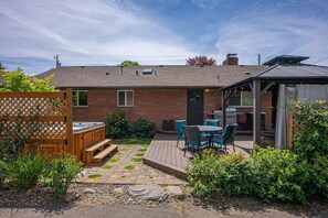Un giardino sul retro con patio, posti a sedere all'aperto e un'area barbecue.