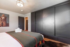Une chambre d’hôtel avec un lit, une armoire et un tableau au mur.