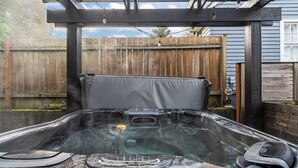 A hot tub with a wooden deck and a pergola overhead. - Bright and modern 2bd/2.5ba- close to Alberta st! (Portland)