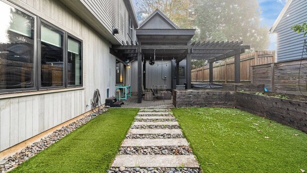 A modern house with a covered patio, a stone pathway, and a well-maintained lawn. - Bright and modern 2bd/2.5ba- close to Alberta st! (Portland)