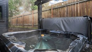 A hot tub with a wooden fence in the background.