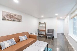 A modern living room with a brown sofa, a marble coffee table, and a painting on the wall. - 2 Bed/1 Bath in NE - Close to Mississippi Ave (Portland)