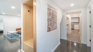 A modern interior with a wooden door, a map on the wall, and a kitchen area visible through an archway. - 2 Bed/1 Bath in NE - Close to Mississippi Ave (Portland)