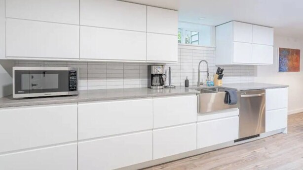 A modern kitchen with white cabinetry, a microwave, a coffee maker, and a dishwasher. - 2 Bed/1 Bath in NE - Close to Mississippi Ave (Portland)
