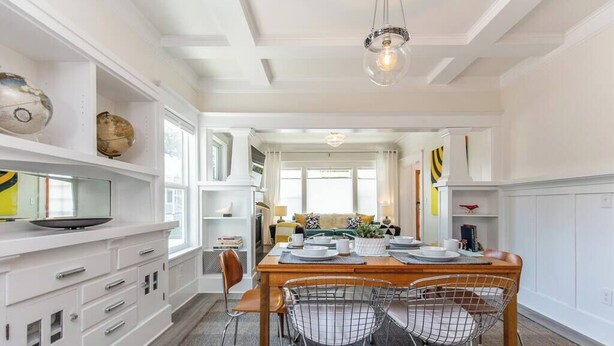 A dining area with a wooden table, wire chairs, and a chandelier. - Modern, Sleek & Stylish: 2 blocks from Hawthorne! (Portland)