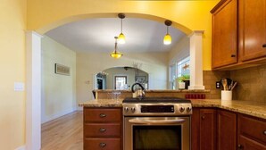 Una cocina con horno de acero inoxidable, armarios de madera y encimera de granito.