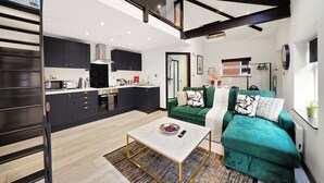 A modern loft apartment with a kitchen, living area, and a mezzanine. - Elegant Yorkshire Abode - Great Location - Sleeps 19 (Castleford)