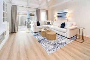 A modern living room with a sectional sofa, a coffee table, and a patterned rug.