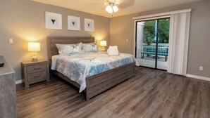 Un dormitorio con cama de madera, mesitas de noche y vistas a un balcón.