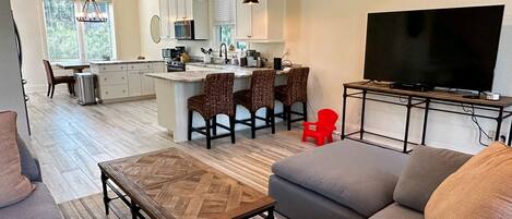 A modern living room with a sofa, a coffee table, and a TV.