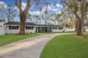 A single-story house with a front entrance, a driveway, and a lawn.