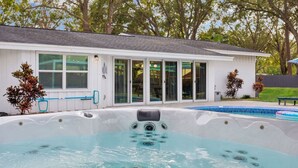 Une maison dotée d’un jacuzzi, d’une piscine et d’un patio couvert.