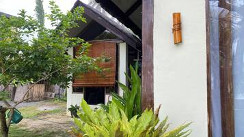 A house with a covered porch, a wooden door, and a potted plant in the foreground.