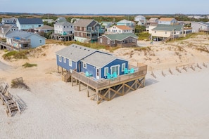 Une propriété située en bord de mer, comprenant plusieurs maisons, dont certaines sont dotées de terrasses surélevées.