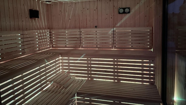 A sauna with wooden benches and a ceiling with embedded lights. - Holiday Homes Near the Sea, Sauna, Whirlpool (Ustronie Morskie)