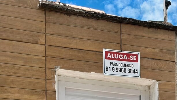Una puerta blanca con un letrero arriba que dice "ALUGA-SE PARA COMERCIO 819 9960 3844".