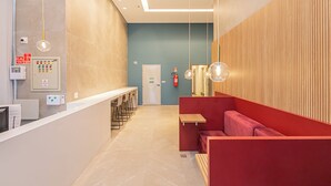 Un espace d’accueil moderne comprenant un comptoir, des sièges et un panneau de commande du système d’alarme incendie.