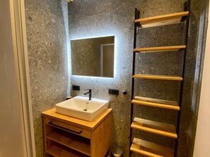 A bathroom with a white sink, a mirror, and a wooden vanity. - Chalet in Saalfelden Near Ski Slopes (Saalfelden am Steinernen Meer)
