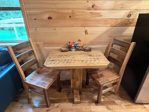 Un tavolo da pranzo in legno con quattro sedie, in una sala con pareti in legno.