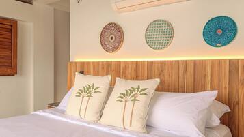 A bedroom with a wooden headboard, a bed with white bedding, and decorative wall art.