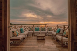 An outdoor seating area with wooden furniture and cushions, overlooking a scenic view. - Soy Local Islawa (Cartagena)